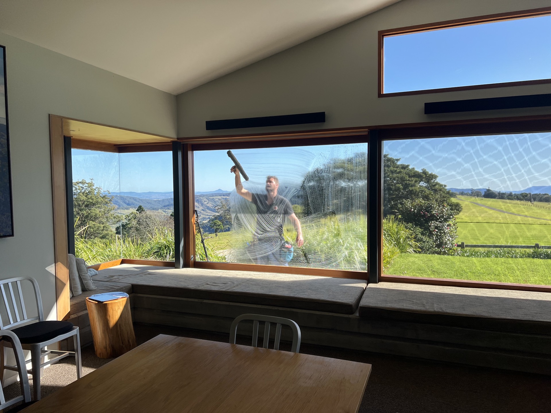 Rhys cleaning a picture window with crystal-clear views beyond - Surfers Paradise context