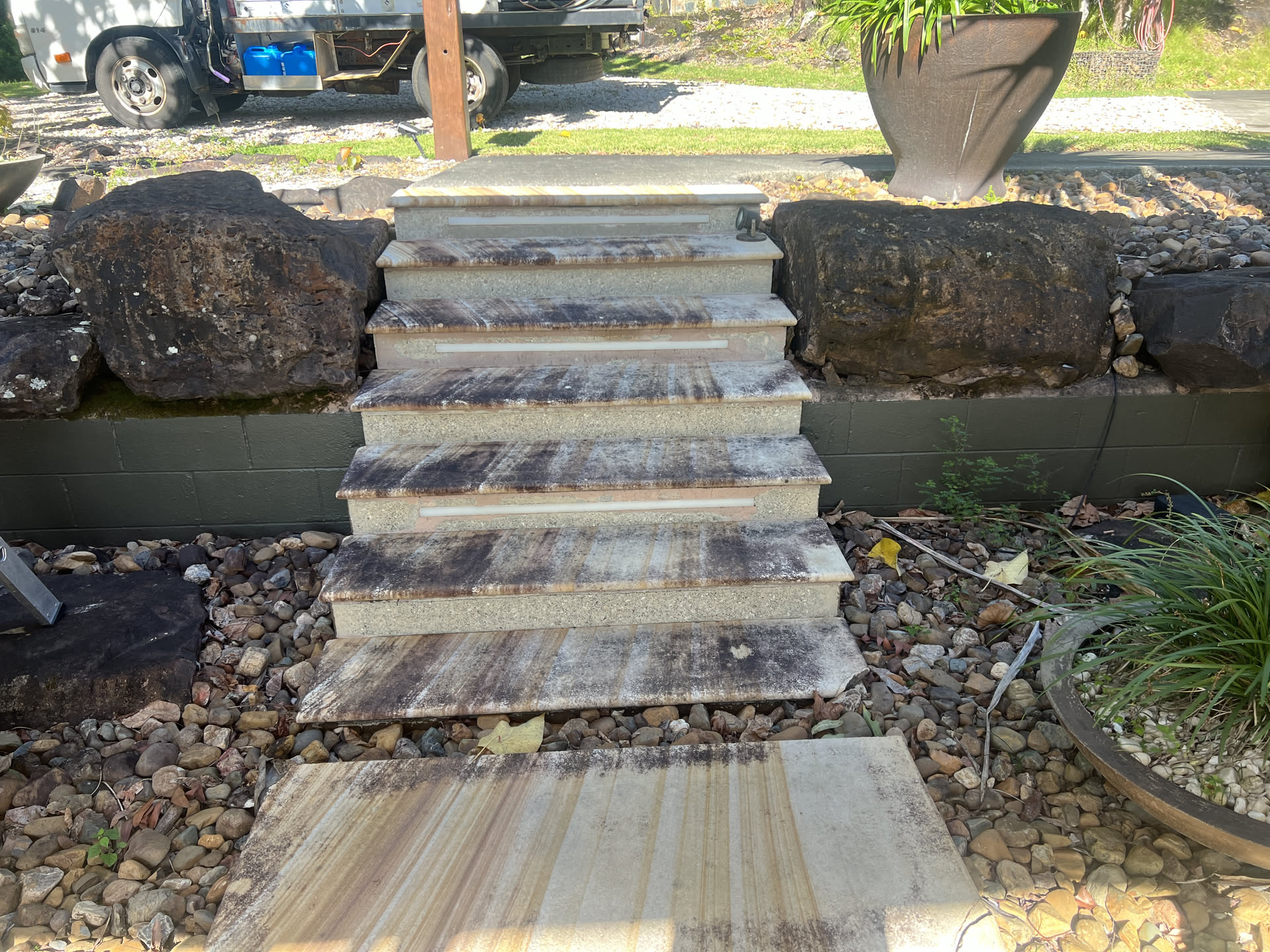 Sandstone entry steps before cleaning, dark mould and grime staining the treads at a Currumbin Valley home