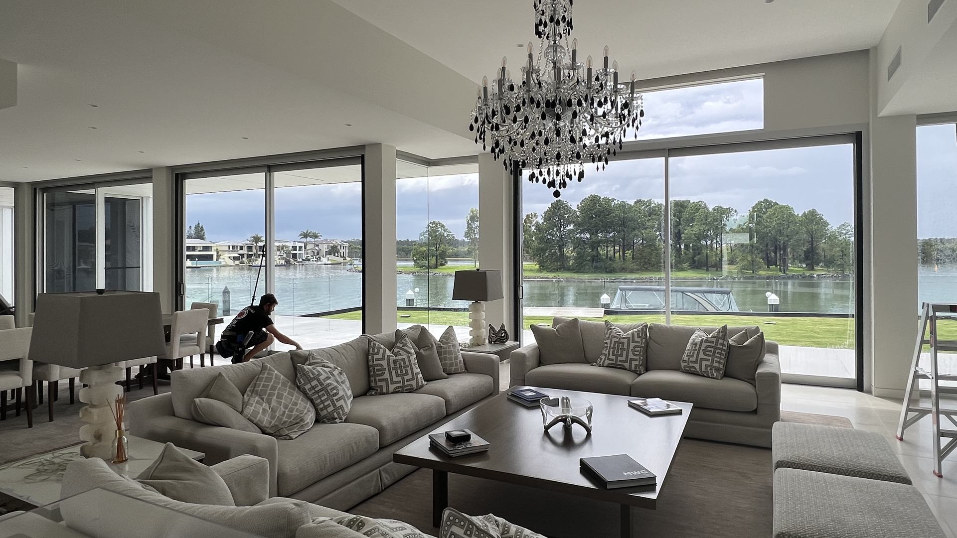Clean floor-to-ceiling glass looking out over the water from a Hope Island living room