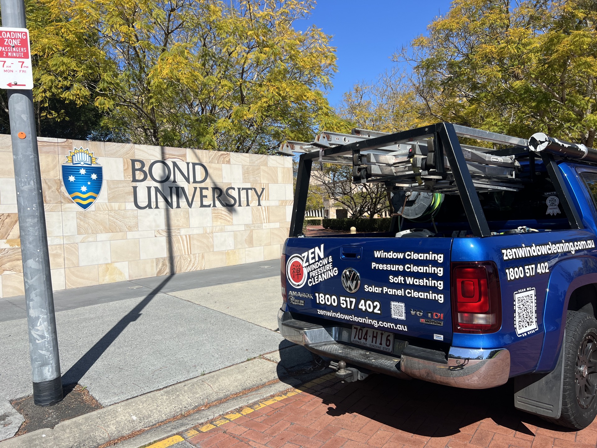 Zen Window Cleaning ute at the Bond University entrance sign