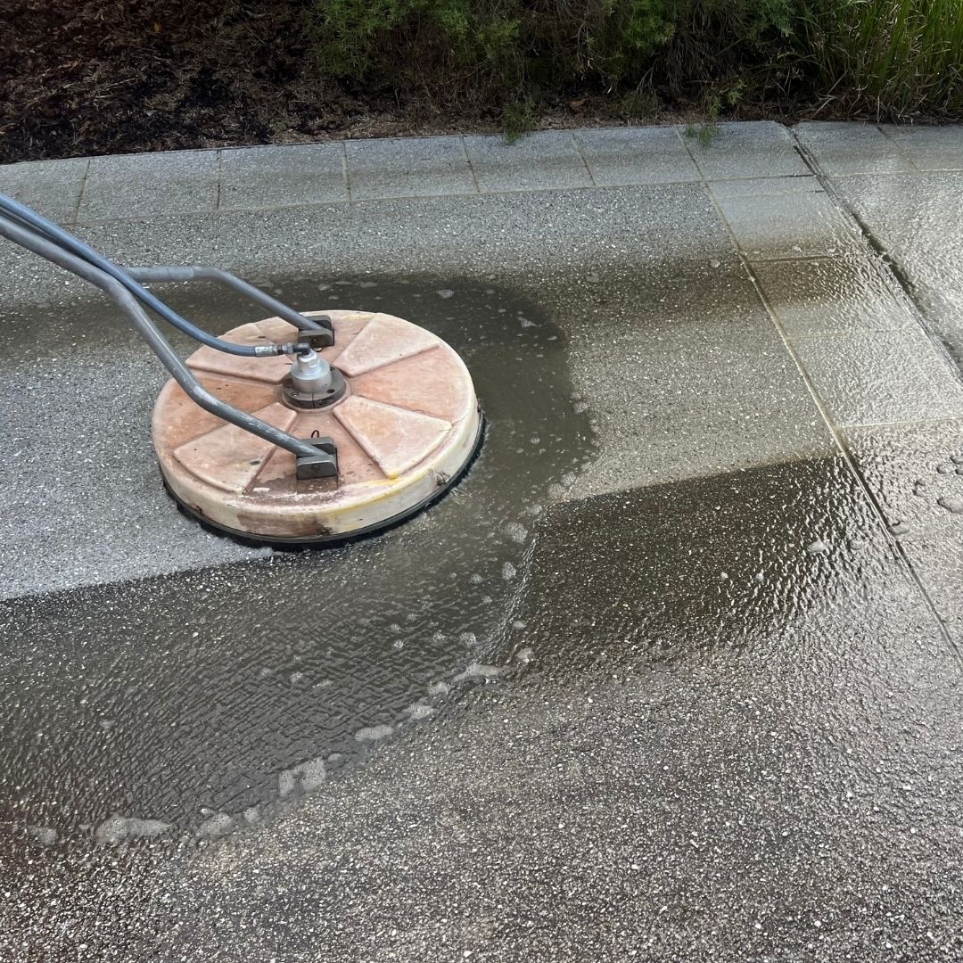 Driveway and concrete cleaning on a Gold Coast property - rotary surface cleaner in action