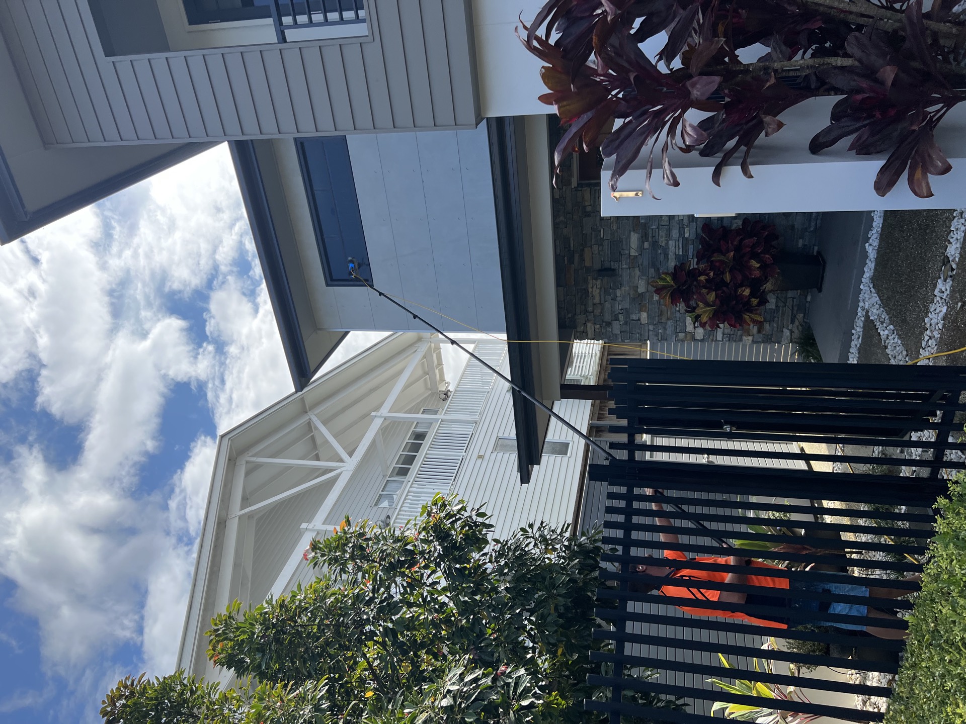 High window cleaning on Gold Coast home using water-fed pole system reaching upper storey windows